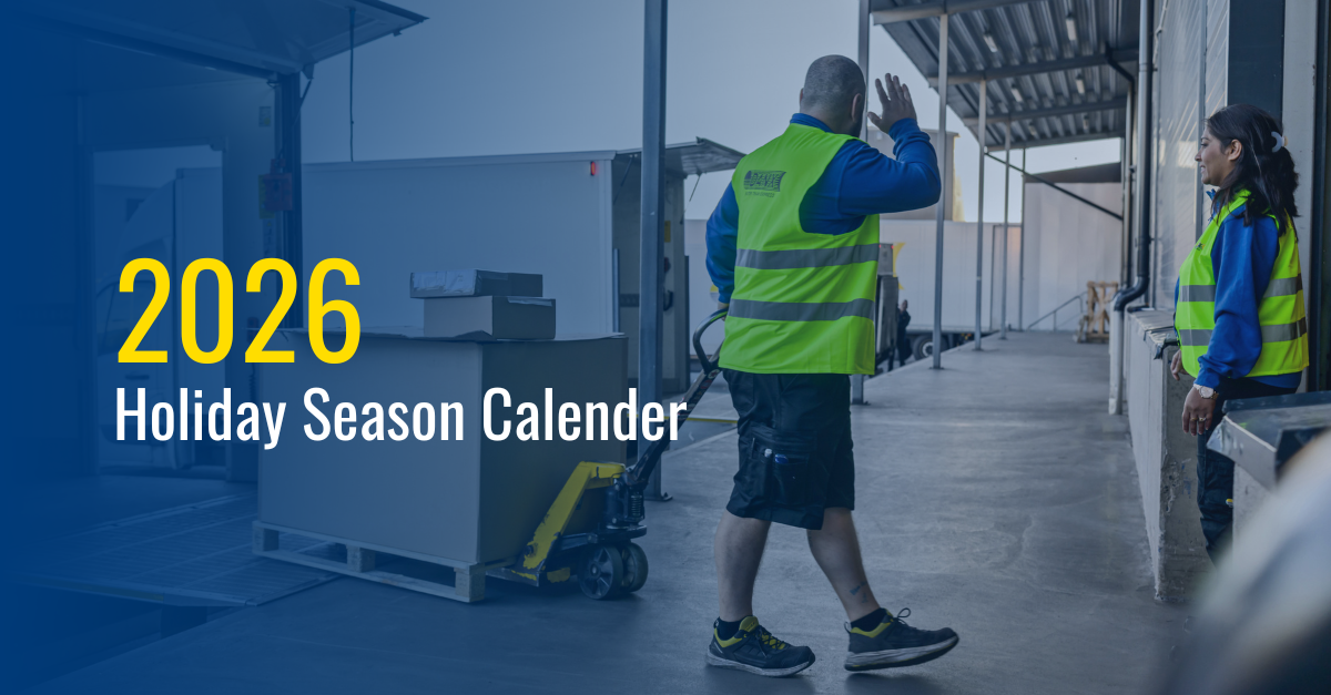 Logistics staff working outside terminal, waving while moving trolley